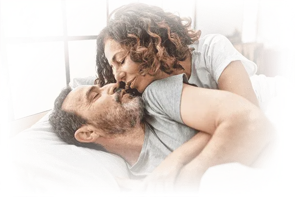 Prostavive reviews Happy middle-aged couple embracing in bed, smiling and enjoying a moment of closeness and intimacy.